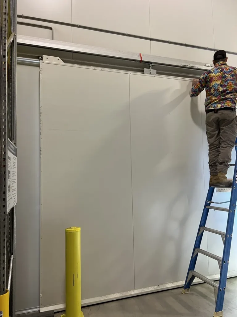 Worker on ladder fixing sliding door