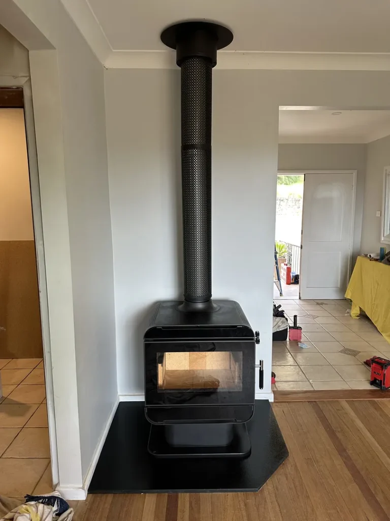 Modern black wood stove installed in a living room.