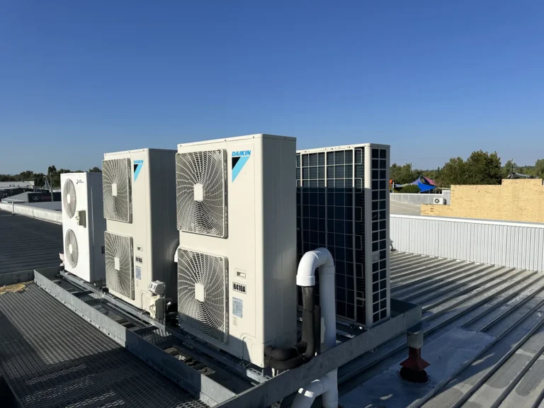 Rooftop air conditioning units on metal surface.