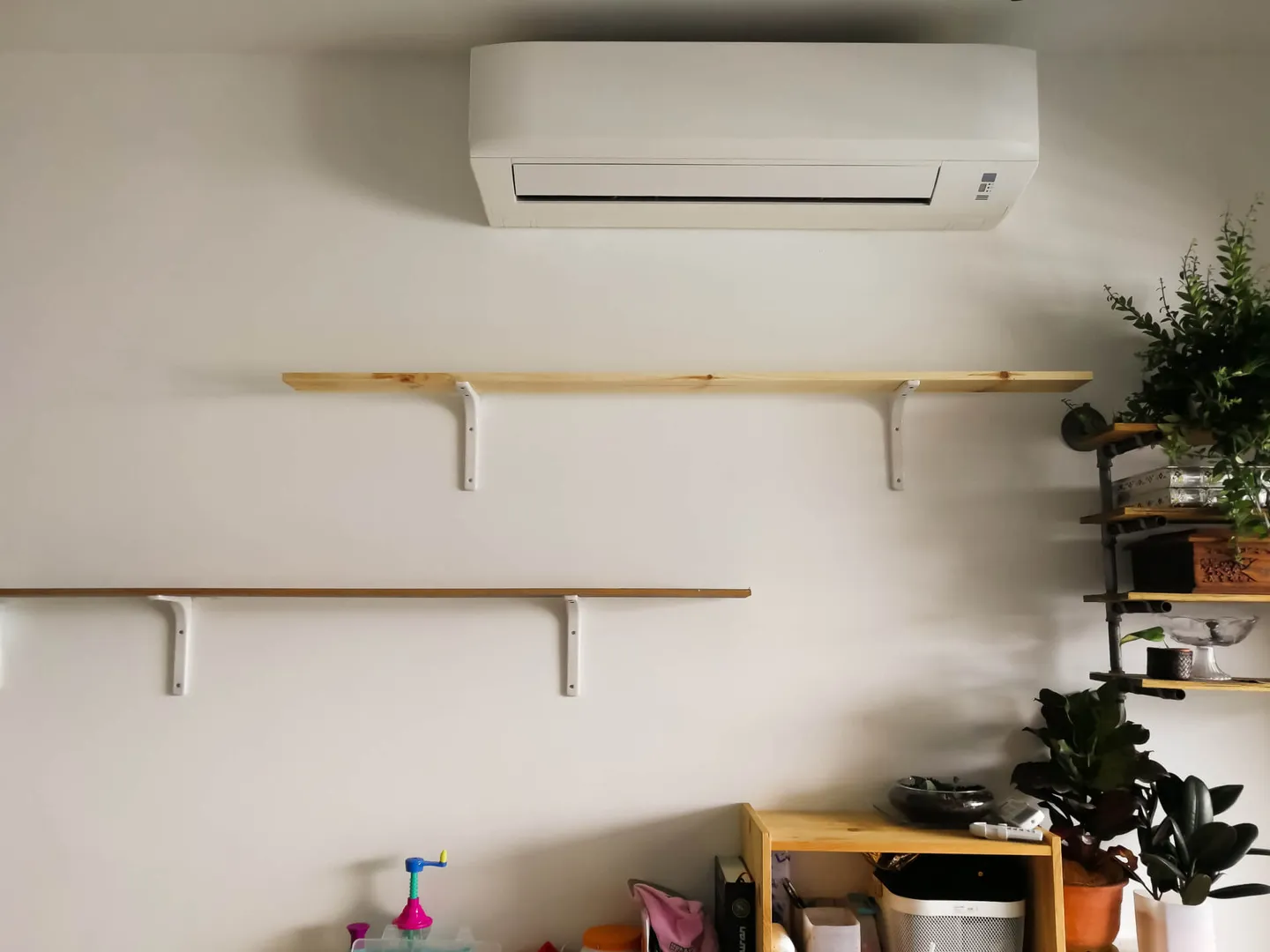 Air conditioner above mounted shelves in home.