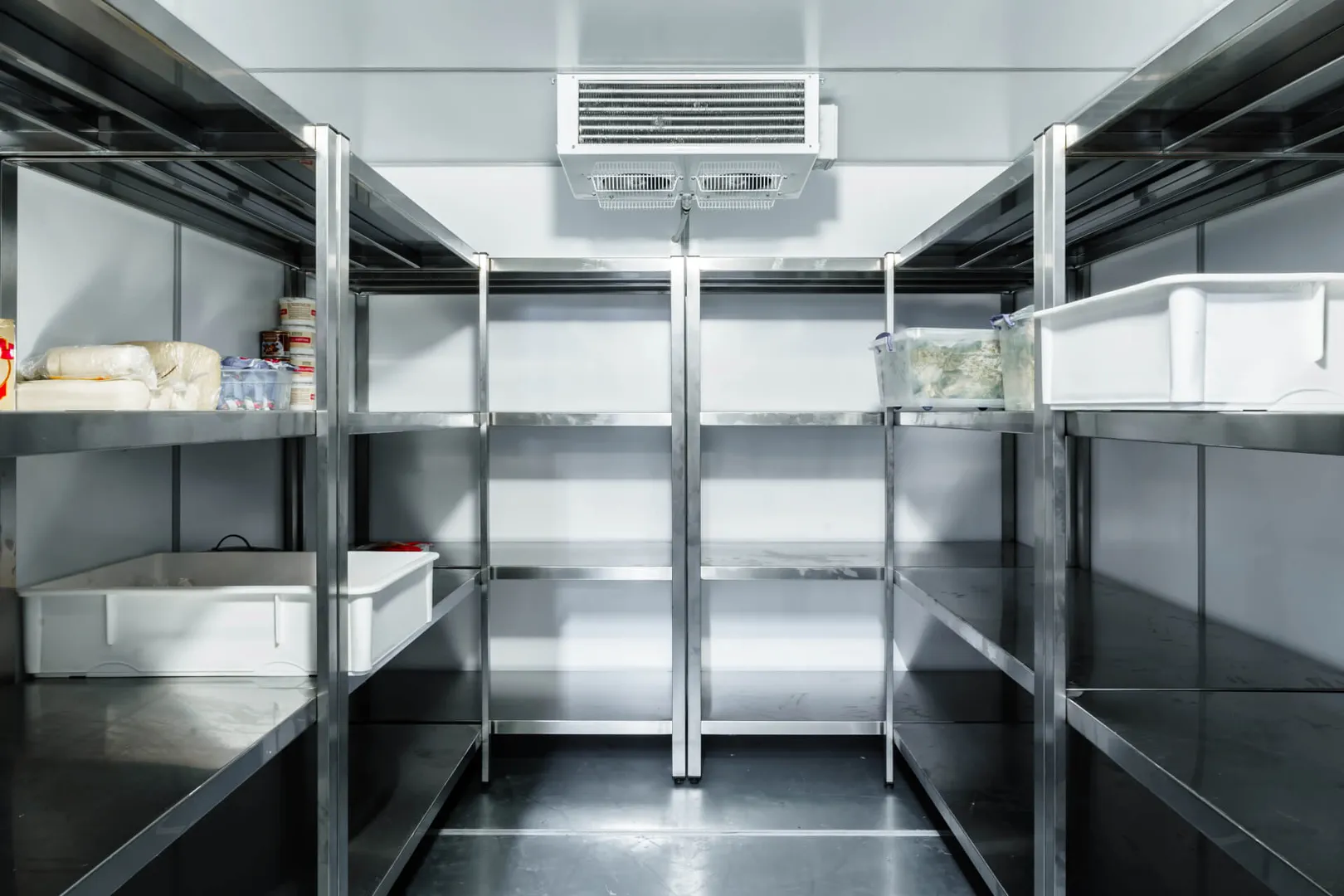 Organized commercial refrigerator with metal shelves and food.